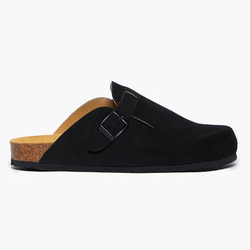 A Black suede clog shoe with a buckle-up closure, adjustable strap, a flat cork insole and EVA outsole. Handmade in Spain
